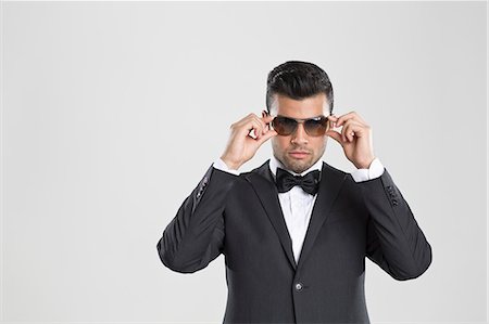 Man in tuxedo adjusting his sunglasses Foto de stock - Sin royalties Premium, Código: 649-06353187