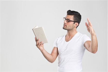 styles - Man gesturing and reading book Stock Photo - Premium Royalty-Free, Code: 649-06353180