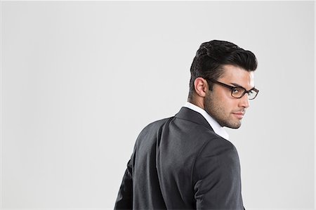 eyeglasses studio - Businessman looking over his shoulder Stock Photo - Premium Royalty-Free, Code: 649-06353183