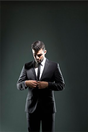 Businessman buttoning suit jacket Fotografie stock - Premium Royalty-Free, Codice: 649-06353196