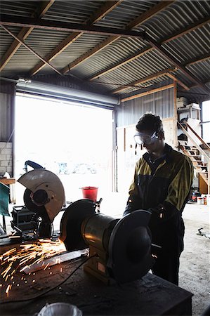 Metal worker using grinder in shop Foto de stock - Sin royalties Premium, Código: 649-06353335