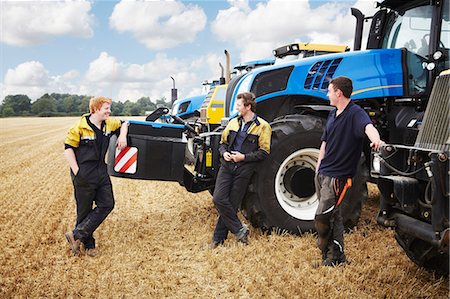 smiling farm worker - Farmers talking by machinery in field Stock Photo - Premium Royalty-Free, Code: 649-06353337