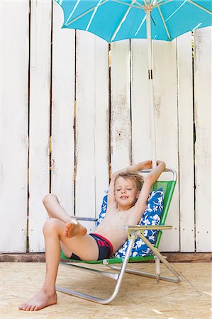 Garçon en maillot de bain dans la chaise de jardin à l'intérieur Photographie de stock - Premium Libres de Droits, Code: 649-06353343