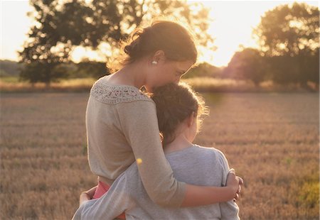 simsearch:649-05950472,k - Mother and daughter hugging in field Fotografie stock - Premium Royalty-Free, Codice: 649-06353362