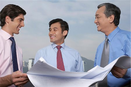 Businessmen reading blueprints together Stock Photo - Premium Royalty-Free, Code: 649-06353438