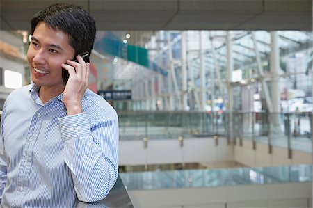 Businessman on cell phone on city street Stock Photo - Premium Royalty-Free, Code: 649-06353470