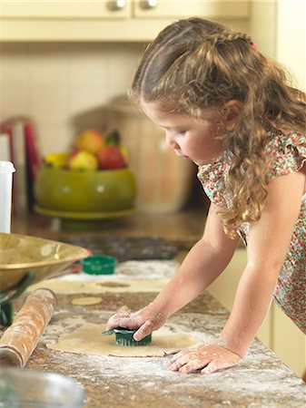 Girl cutting out cookies in kitchen Foto de stock - Sin royalties Premium, Código: 649-06400426