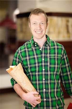 retailer - Man carrying baguette in grocery store Stock Photo - Premium Royalty-Free, Code: 649-06400433