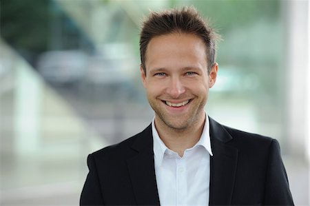 portrait businessmen outside - Smiling businessman standing at window Stock Photo - Premium Royalty-Free, Code: 649-06400686