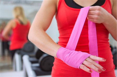 pegar con cinta dhesiva - Boxer wrapping her hands in gym Foto de stock - Sin royalties Premium, Código: 649-06400793