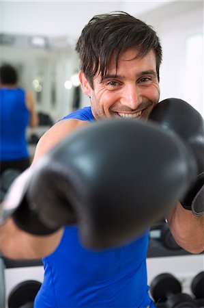 puñetazos - Boxer wearing boxing gloves in gym Foto de stock - Sin royalties Premium, Código: 649-06400816
