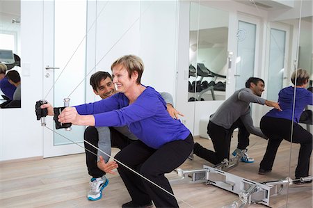 senior gym - Trainer adjusting woman's form in gym Stock Photo - Premium Royalty-Free, Code: 649-06400820