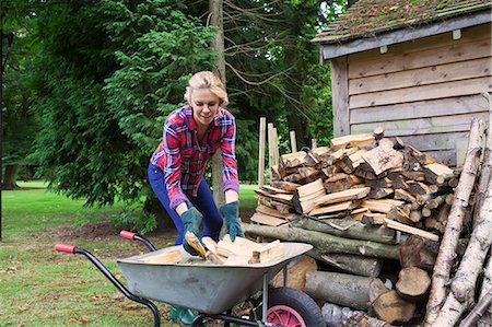 Woman loading firewood into wheelbarrow Foto de stock - Sin royalties Premium, Código: 649-06400844