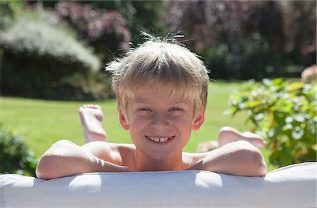 rubio - Smiling boy laying on sofa outdoors Foto de stock - Sin royalties Premium, Código: 649-06400859