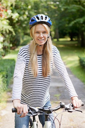 Woman riding bicycle on rural road Stock Photo - Premium Royalty-Free, Code: 649-06400862