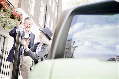 sustainable transportation - Couple charging electric car on street Stock Photo - Premium Royalty-Free, Code: 649-06401082