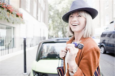 sustainable future - Woman holding car keys on city street Stock Photo - Premium Royalty-Free, Code: 649-06401099