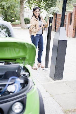 enjeux écologiques - Femme recharge voiture électrique dans la rue Photographie de stock - Premium Libres de Droits, Code: 649-06401107