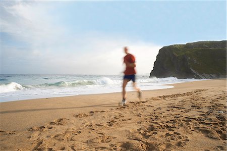Man running on beach Foto de stock - Sin royalties Premium, Código: 649-06401171