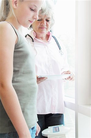 stethoscope two girls - Doctor checking girl's weight Stock Photo - Premium Royalty-Free, Code: 649-06401259