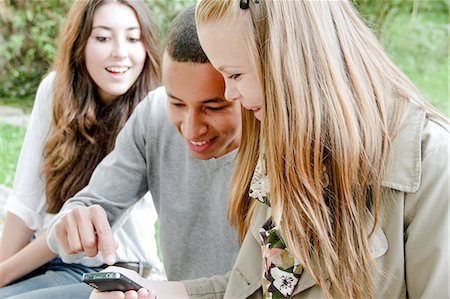 Teenagers using cell phone outdoors Stock Photo - Premium Royalty-Free, Code: 649-06401278