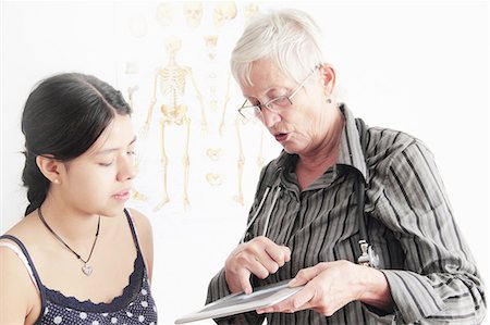 freiburg - Doctor showing x-ray to teenage girl Stock Photo - Premium Royalty-Free, Code: 649-06401287