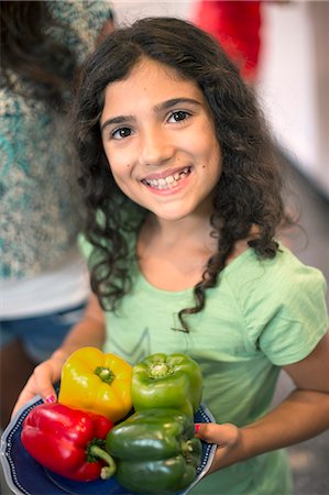 Smiling girl holding bowl of peppers Stock Photo - Premium Royalty-Free, Code: 649-06401419