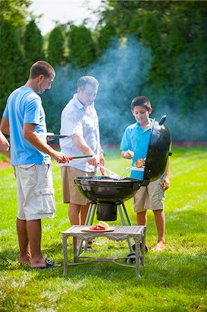 dad helping child - Father and sons grilling outdoors Stock Photo - Premium Royalty-Free, Code: 649-06401460