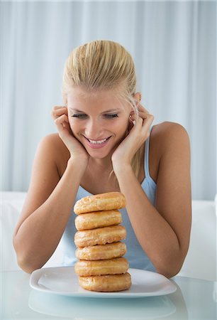 diet happy - Woman admiring stack of donuts Stock Photo - Premium Royalty-Free, Code: 649-06432252