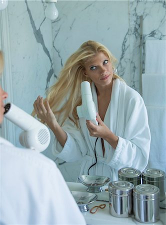 styling hair - Coup de femme séchant ses cheveux dans la salle de bain Photographie de stock - Premium Libres de Droits, Code: 649-06432264