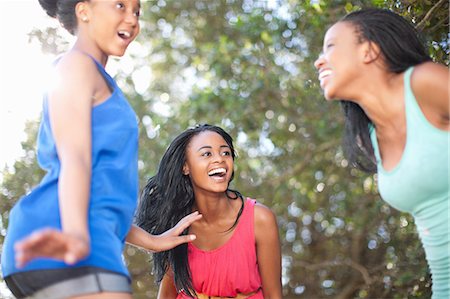 friends smiling together - Smiling women playing outdoors Stock Photo - Premium Royalty-Free, Code: 649-06432343