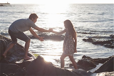 pareja de jóvenes - Couple climbing rocks on beach Foto de stock - Sin royalties Premium, Código: 649-06432370