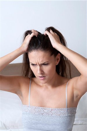 Woman scratching her head in bed Stock Photo - Premium Royalty-Free, Code: 649-06432466
