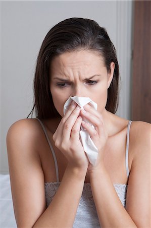 people upset not senior not child - Woman blowing her nose on bed Stock Photo - Premium Royalty-Free, Code: 649-06432470