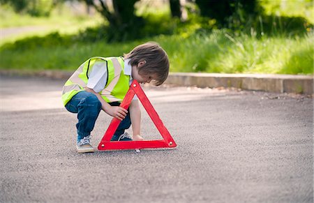 prudenza - Boy playing traffic worker on rural road Fotografie stock - Premium Royalty-Free, Codice: 649-06432496