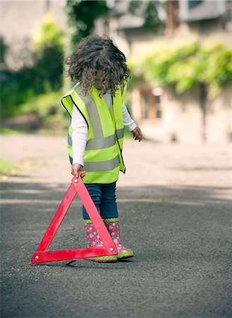 proteger - Girl playing traffic worker on rural road Foto de stock - Royalty Free Premium, Número: 649-06432501