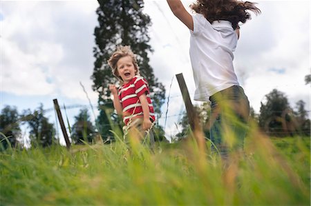 sibling - Children playing in grassy field Stock Photo - Premium Royalty-Free, Code: 649-06432503