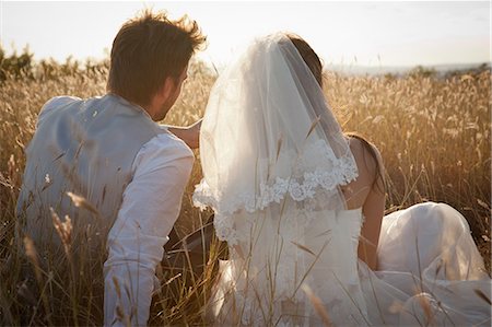 Newlywed couple sitting in tall grass Stock Photo - Premium Royalty-Free, Code: 649-06432579