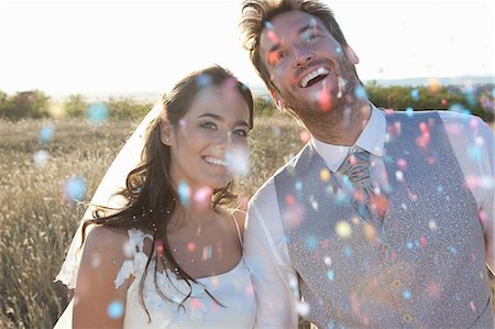 Newlywed couple walking in confetti Stock Photo - Premium Royalty-Free, Code: 649-06432593