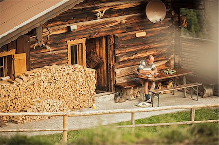 retire house - Man reading in porch of log cabin Stock Photo - Premium Royalty-Free, Code: 649-06432609