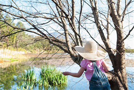 Girl playing on tree outdoors Stock Photo - Premium Royalty-Free, Code: 649-06432672