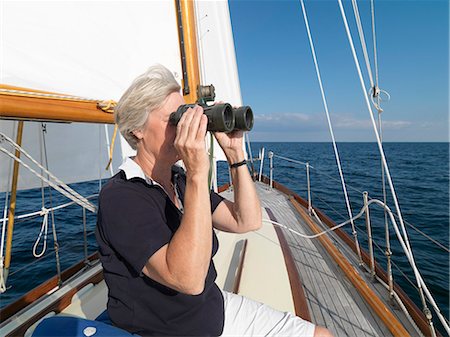 Femme plus âgée, à l'aide de jumelles sur voilier Photographie de stock - Premium Libres de Droits, Code: 649-06432705