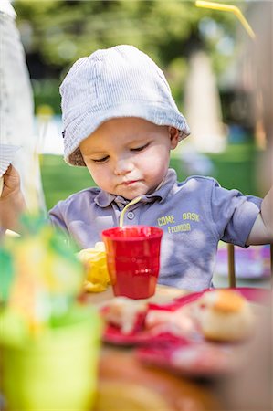 Toddler boy eating at table outdoors Stock Photo - Premium Royalty-Free, Code: 649-06432769