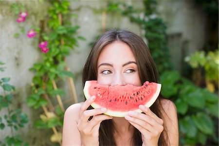 red watermelon - Femme souriante, jouant avec le melon d'eau Photographie de stock - Premium Libres de Droits, Code: 649-06432891