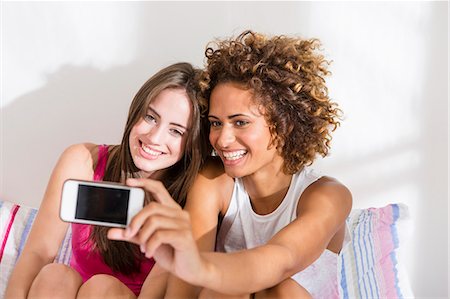 selfie cell phone indoor - Women taking picture with cell phone Stock Photo - Premium Royalty-Free, Code: 649-06432901