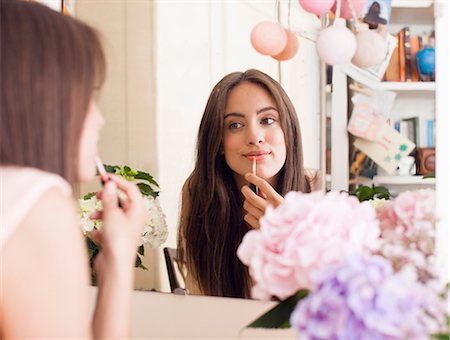 Woman applying make up in mirror Stock Photo - Premium Royalty-Free, Code: 649-06432941