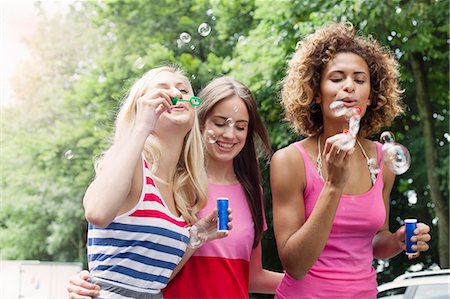 Smiling women blowing bubbles outdoors Stock Photo - Premium Royalty-Free, Code: 649-06432955