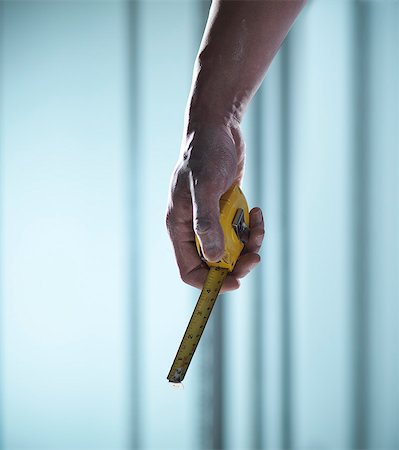Close up of hand holding measuring tape Stock Photo - Premium Royalty-Free, Code: 649-06432967