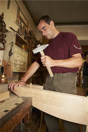 Worker hammering nail into wood Stock Photo - Premium Royalty-Free, Code: 649-06433439