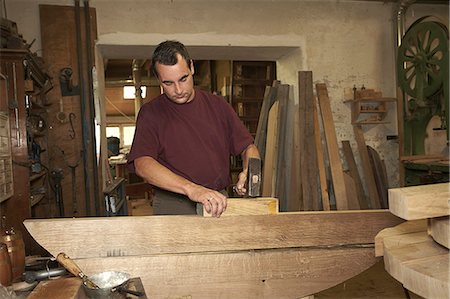 Worker hammering wood in shop Foto de stock - Sin royalties Premium, Código: 649-06433441